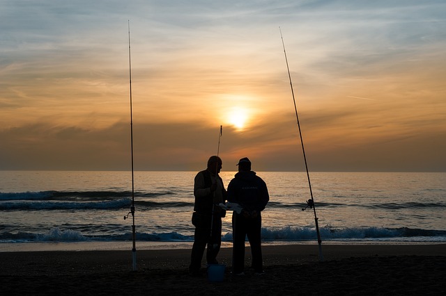 pescatori in riva al mare con canna per pesca a feeder